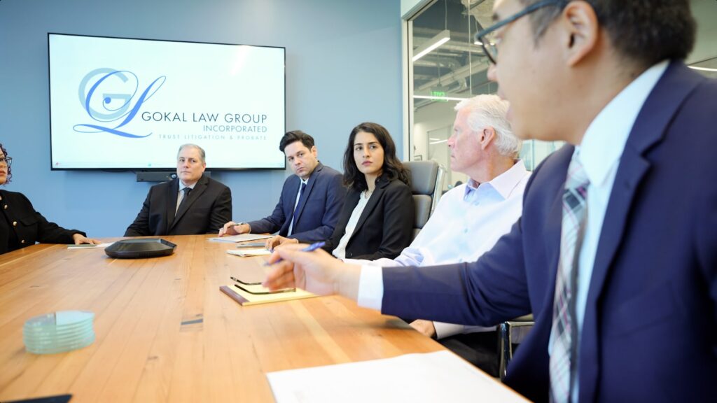 Andrew Micaraset talking to the Gokal team about how to prove undue influence in a will or trust at a conference table in the Gokal Law Group office.