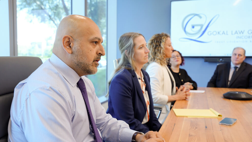 The team at Gokal Law Group sitting around a conference table and discussing a case that revolves around the question, Can an executor decide who gets what?