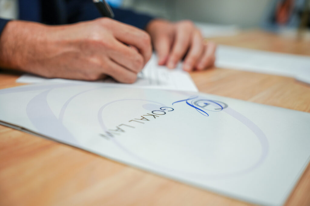 A member of the Gokal Law Group team writing something as they work on a case that revolves around an executor not communicating with beneficiaries in California.